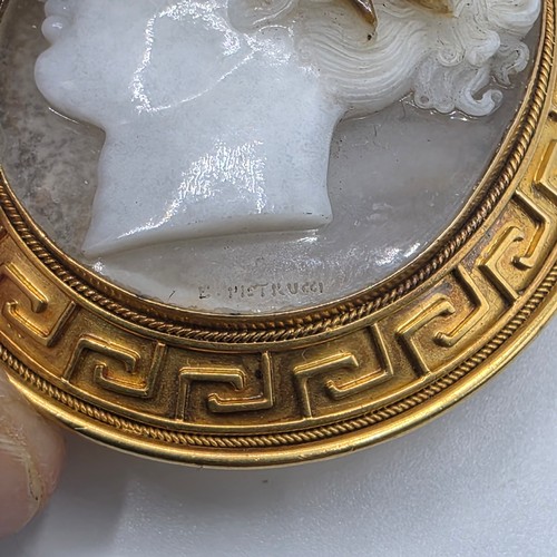 3 - Elena Pistrucci (1822-1886) An unmarked yellow metal hardstone cameo brooch with Greek key oval surr... 