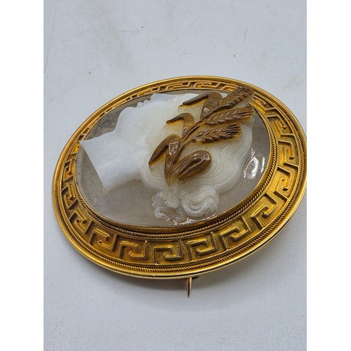 3 - Elena Pistrucci (1822-1886) An unmarked yellow metal hardstone cameo brooch with Greek key oval surr... 