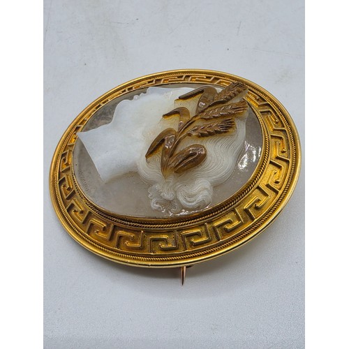 3 - Elena Pistrucci (1822-1886) An unmarked yellow metal hardstone cameo brooch with Greek key oval surr... 