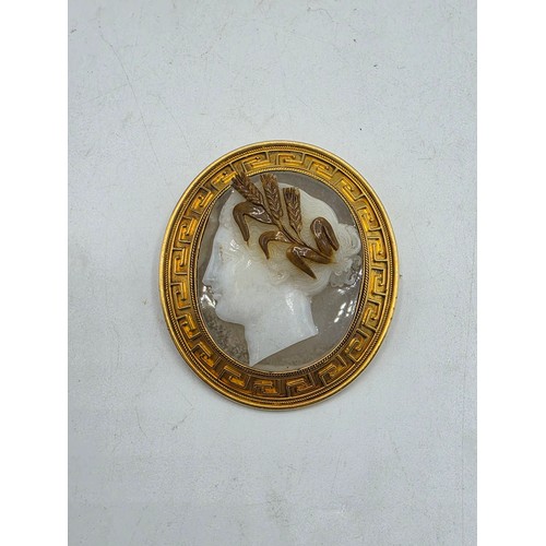 3 - Elena Pistrucci (1822-1886) An unmarked yellow metal hardstone cameo brooch with Greek key oval surr... 