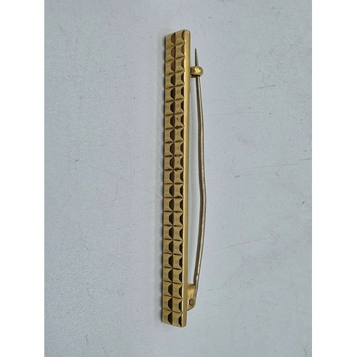 12 - An 18ct gold bar brooch with geometric textured design. 9.9g.