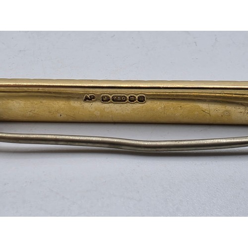 12 - An 18ct gold bar brooch with geometric textured design. 9.9g.