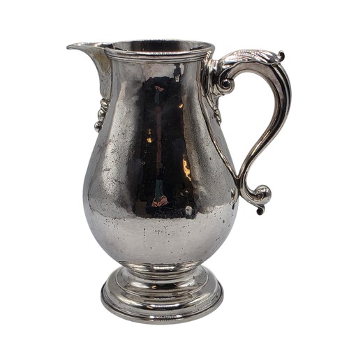 17 - A sterling silver hand planished water jug on circular stepped foot with scroll handle by SJ Phillip... 