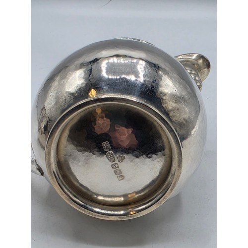 18 - Two matching sterling silver hand planished jugs together with matching hand planished sterling silv... 