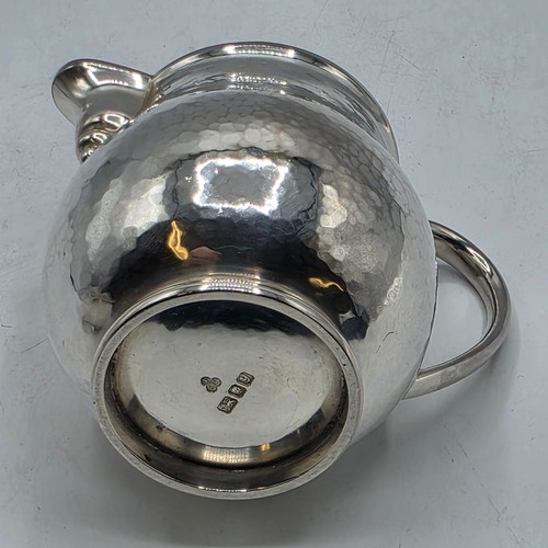 18 - Two matching sterling silver hand planished jugs together with matching hand planished sterling silv... 