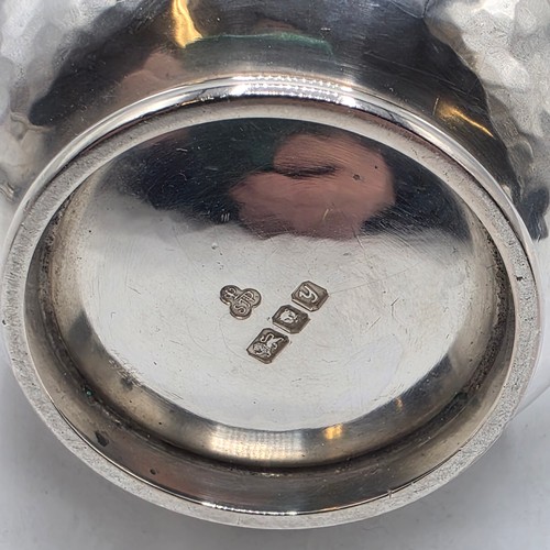 18 - Two matching sterling silver hand planished jugs together with matching hand planished sterling silv... 