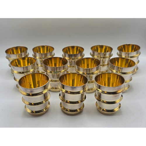 27 - A set of twelve  Sterling silver gilt water beakers with gilt ribbed design and interiors each 9.5 c... 