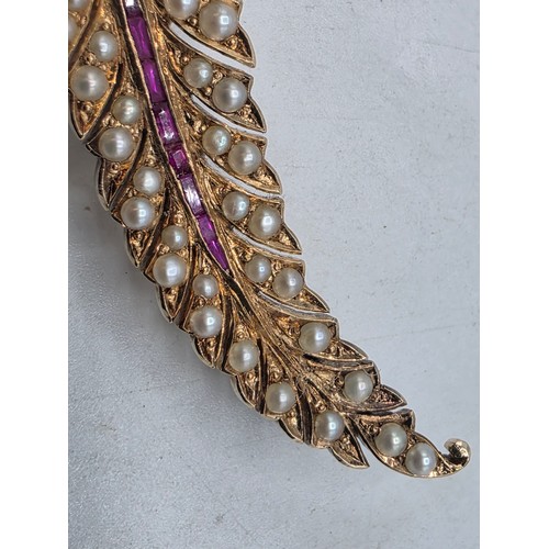 25 - An unmarked yellow metal pearl and ruby Fern Brooch set with graduated line of channel set rubies an... 