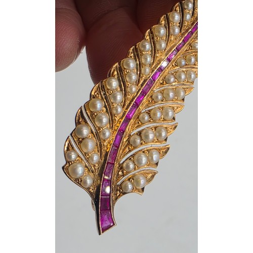 25 - An unmarked yellow metal pearl and ruby Fern Brooch set with graduated line of channel set rubies an... 