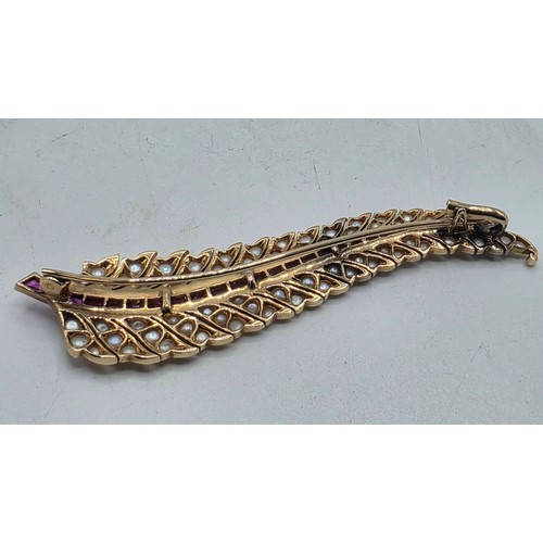 25 - An unmarked yellow metal pearl and ruby Fern Brooch set with graduated line of channel set rubies an... 