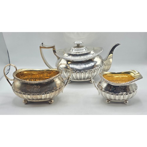 43 - A Scottish sterling silver three piece tea set with half fluted design on ball feet. By James McKay,... 