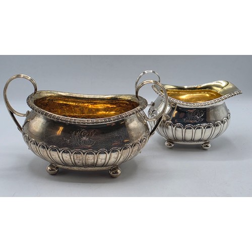 43 - A Scottish sterling silver three piece tea set with half fluted design on ball feet. By James McKay,... 