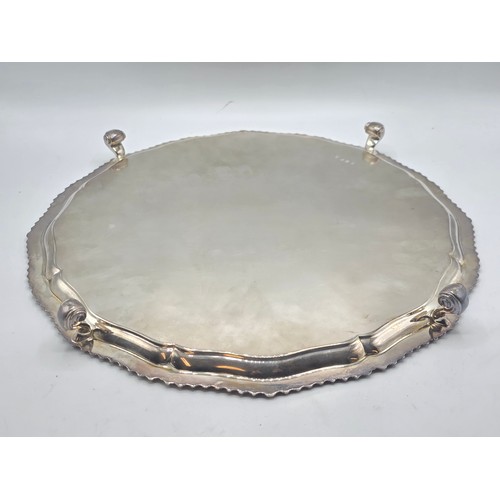 38 - A large sterling silver tray with cast rim and on four scroll feet. 36cm(d). By CJ Vander Ltd Sheffi... 