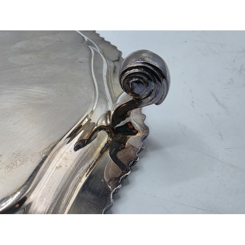 38 - A large sterling silver tray with cast rim and on four scroll feet. 36cm(d). By CJ Vander Ltd Sheffi... 