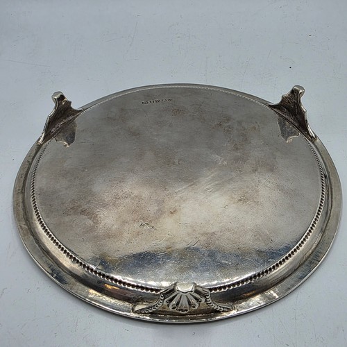 54 - A pair of sterling silver circular card trays or salvers with beaded rims on three shell feet.   Joh... 