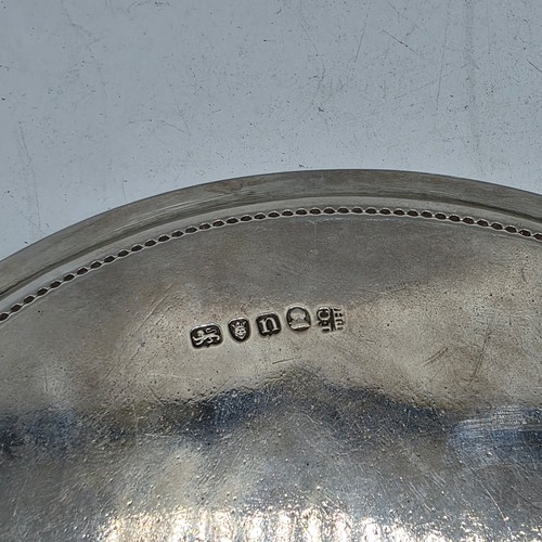 54 - A pair of sterling silver circular card trays or salvers with beaded rims on three shell feet.   Joh... 