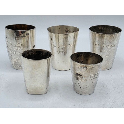 56 - A collection of white metal beakers and a Dunhill white metal engine turned cigarette lighter togeth... 