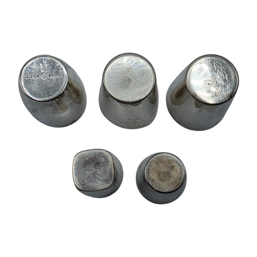 56 - A collection of white metal beakers and a Dunhill white metal engine turned cigarette lighter togeth... 