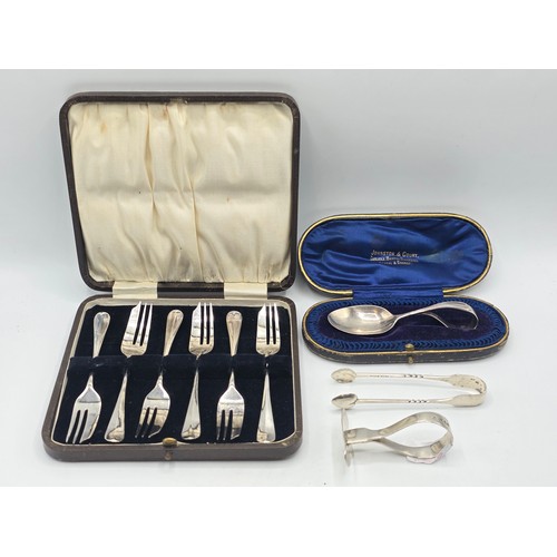 55 - A boxed set of sterling silver cake forks together with a boxed sterling silver christening spoon an... 