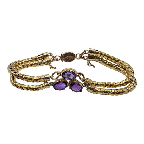 53 - An unmarked yellow metal and amethyst double snake link bracelet set with four free cut oval amethys... 