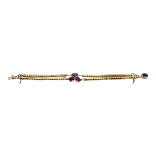 53 - An unmarked yellow metal and amethyst double snake link bracelet set with four free cut oval amethys... 