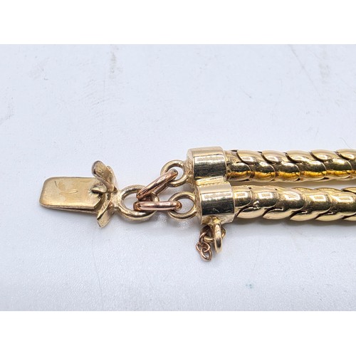 53 - An unmarked yellow metal and amethyst double snake link bracelet set with four free cut oval amethys... 