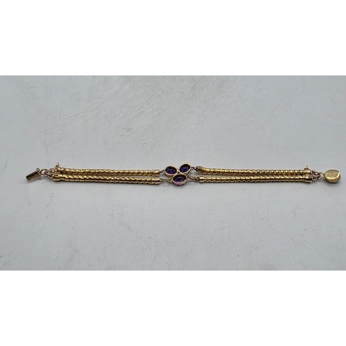 53 - An unmarked yellow metal and amethyst double snake link bracelet set with four free cut oval amethys... 