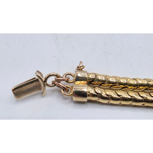 53 - An unmarked yellow metal and amethyst double snake link bracelet set with four free cut oval amethys... 