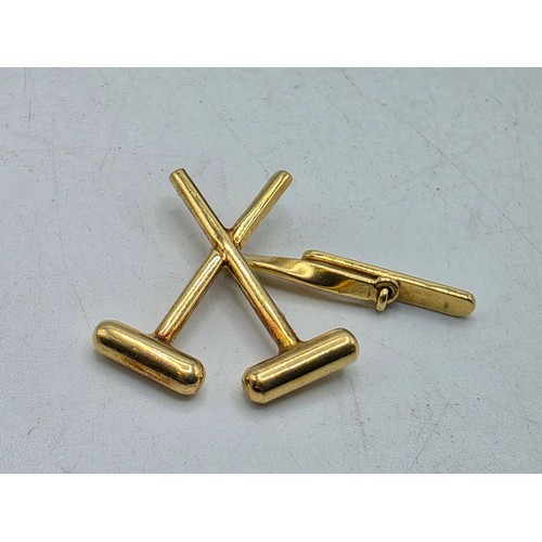 40 - A pair of 18ct gold gents cufflinks in the form of crossed polo mallets.  7.5 g.
