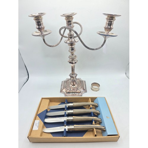 35 - A silver plated table candelabra on square cantered stepped base together with a set of steak knives
