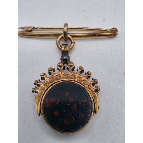 252 - Unmarked yellow metal swivel watch fob with bloodstone panel on 9 ct gold pin brooch, 6.6 g