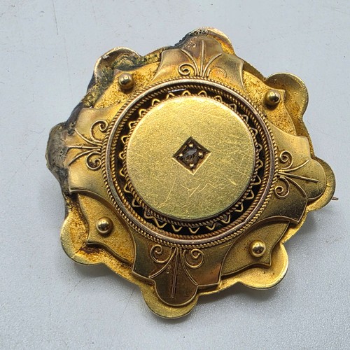251 - A yellow metal Etruscan style wheel brooch with central rose cut diamond 6 g