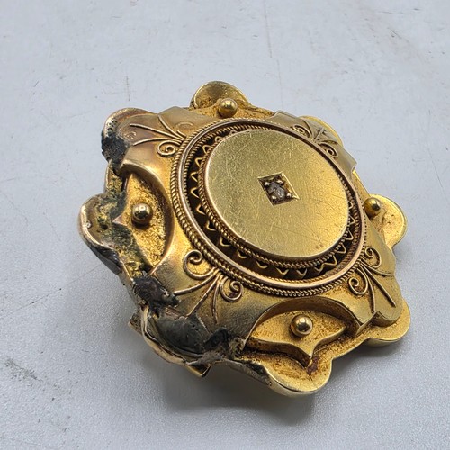 251 - A yellow metal Etruscan style wheel brooch with central rose cut diamond 6 g