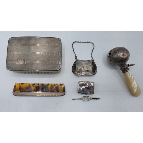 72 - A collection of sterling silver items to include decanter label, pill box, mounted rattle etc