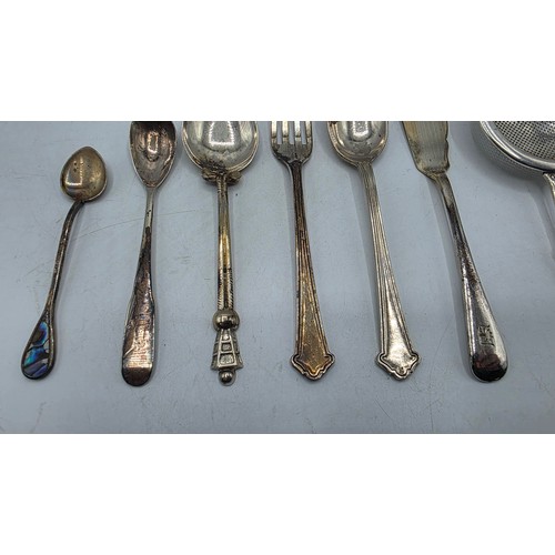 69 - A sterling silver tea strainer together with sterling silver and white metal cutlery items, various ... 