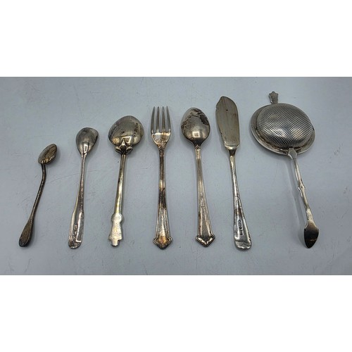 69 - A sterling silver tea strainer together with sterling silver and white metal cutlery items, various ... 