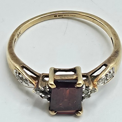 25 - A 9ct gold and garnet set ring with single cut diamond set shoulders. Size P. 2g.