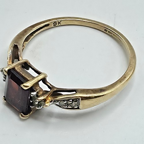 25 - A 9ct gold and garnet set ring with single cut diamond set shoulders. Size P. 2g.