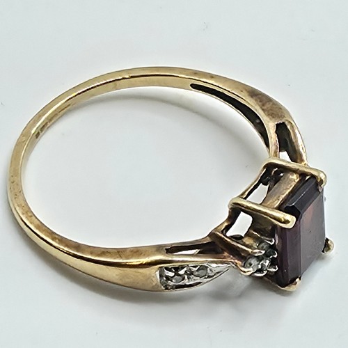 25 - A 9ct gold and garnet set ring with single cut diamond set shoulders. Size P. 2g.