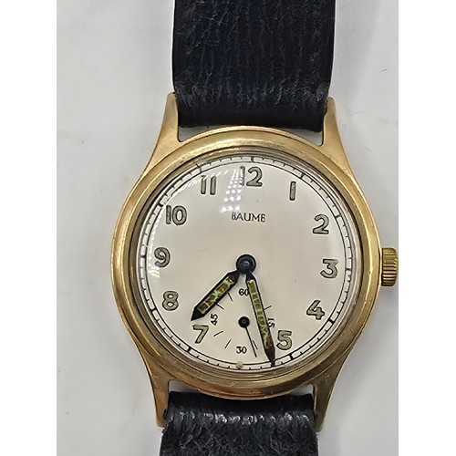 28 - A 9ct gold cased Baume Gents wristwatch. 25mm champagne face with Arabic markers and subsidiary seco... 