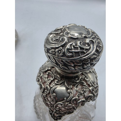 15 - A pair of sterling silver mounted glass scent bottles by Henry Matthews Birmingham, 1898, one with m... 