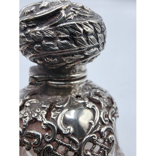 15 - A pair of sterling silver mounted glass scent bottles by Henry Matthews Birmingham, 1898, one with m... 