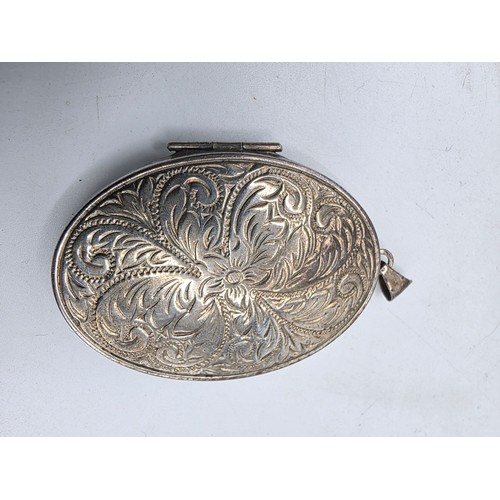 26 - A sterling silver charm bracelet togethjer with an oval locket with chased decoration. Gross weight ... 