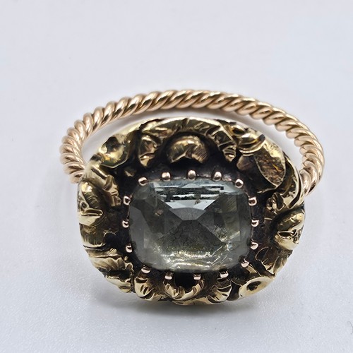 88 - An early 19th Century style unmarked yellow metal and pale green beryl ladies ring with cast floral ... 