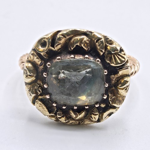 88 - An early 19th Century style unmarked yellow metal and pale green beryl ladies ring with cast floral ... 