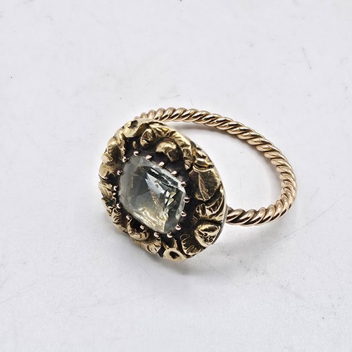 88 - An early 19th Century style unmarked yellow metal and pale green beryl ladies ring with cast floral ... 