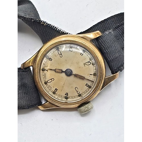 92 - A 9ct gold cased wrist watch 20 mm face with Arabic markers on a fabric strap, gross weight 13 g