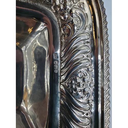 118 - A sterling silver serving dish with repousse decoration and beaded rim by Henry Atkin Sheffield 1894... 