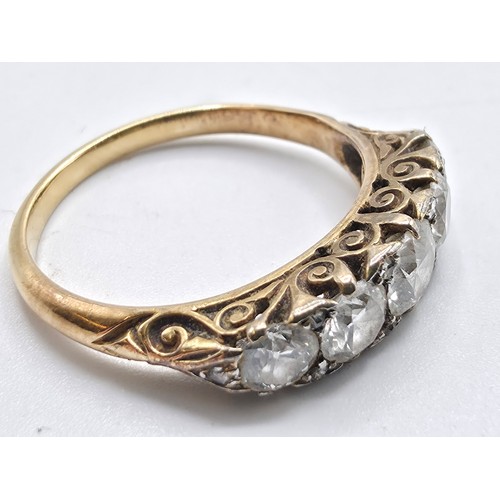 106 - An unmarked yellow metal diamond five stone ring. Line of graduated brilliant cut diamonds with rose... 
