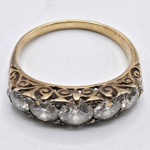 106 - An unmarked yellow metal diamond five stone ring. Line of graduated brilliant cut diamonds with rose... 